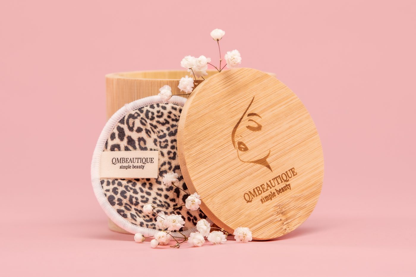 Reusable cotton rounds beside an engraved bamboo case