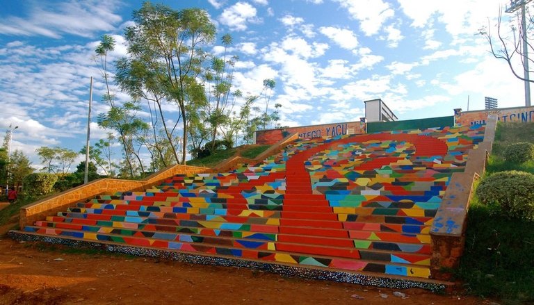 Painted stairs in Kigali covered in a red, yellow, teal and blue geometric mural